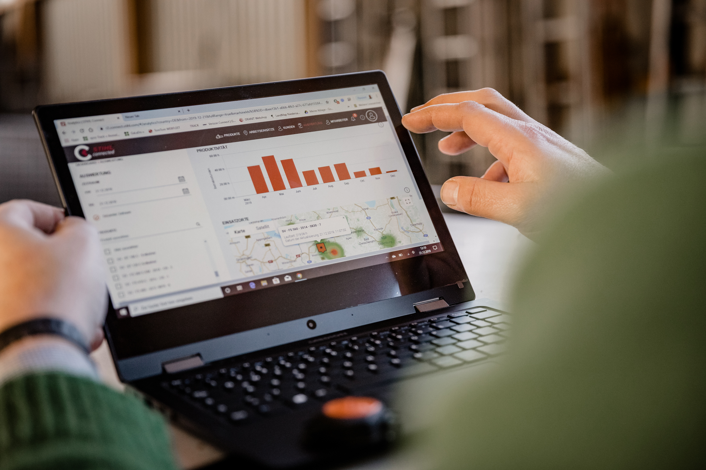 Nahaufnahme einer Person vor einem Laptop, auf dem das STIHL connected Portal geöffnet ist