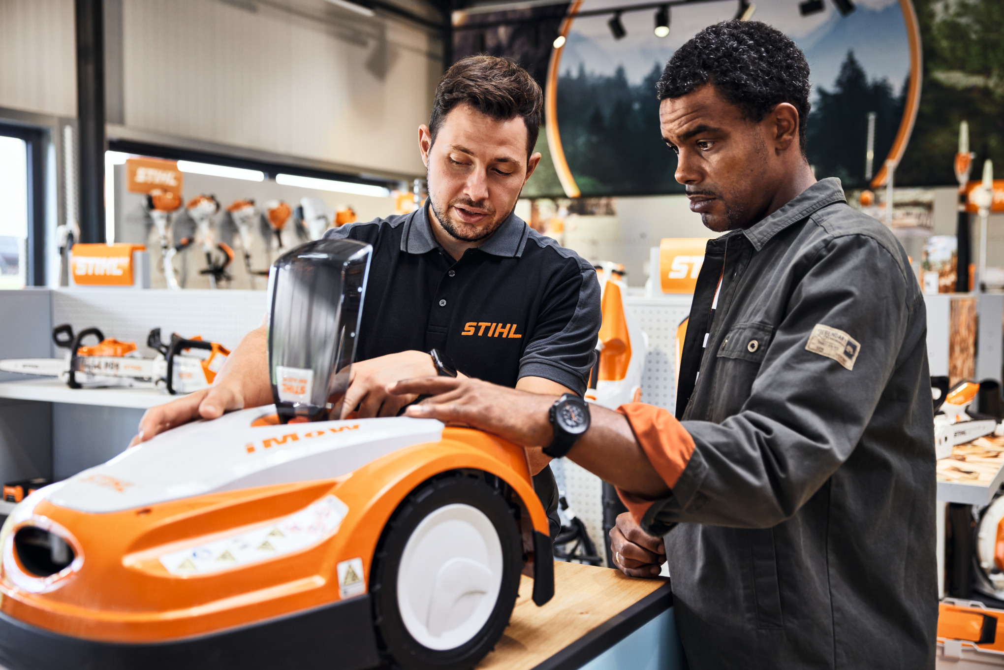 STIHL Fachhändler berät jungen Mann beim Kauf eines STIHL iMOW